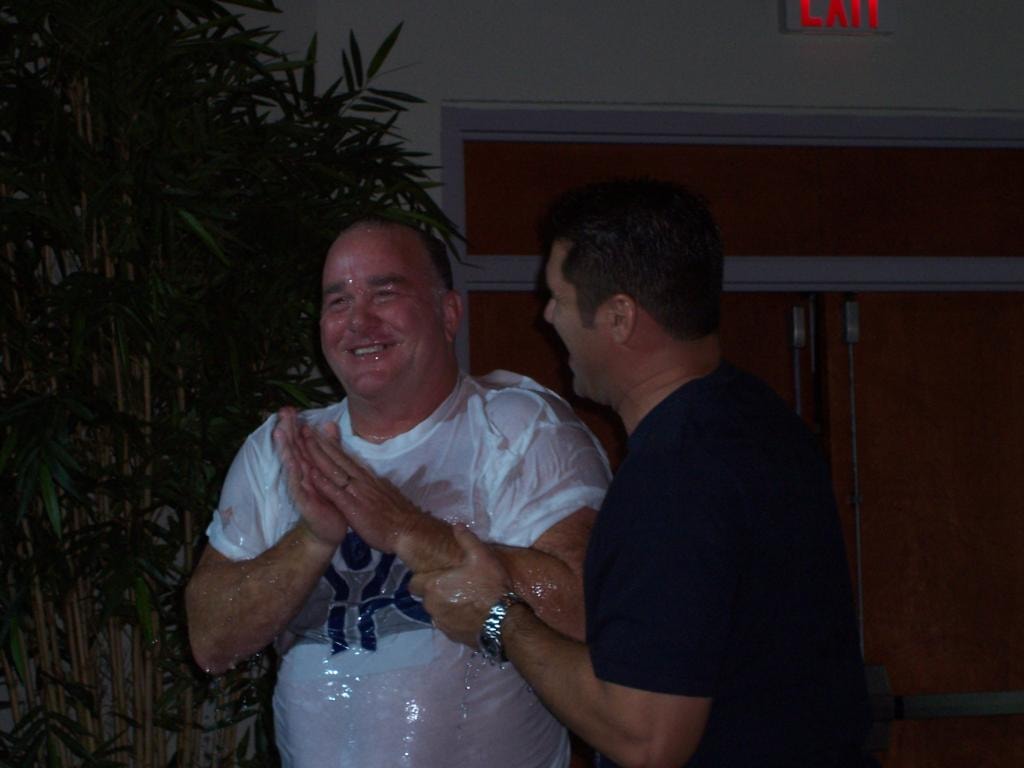 David P. Zettel Jr. being baptized, smiling with hands clasped