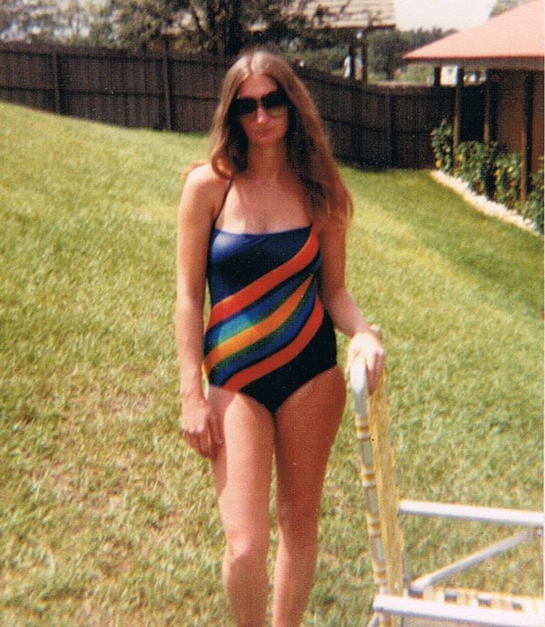 Woman in rainbow swimsuit backyard