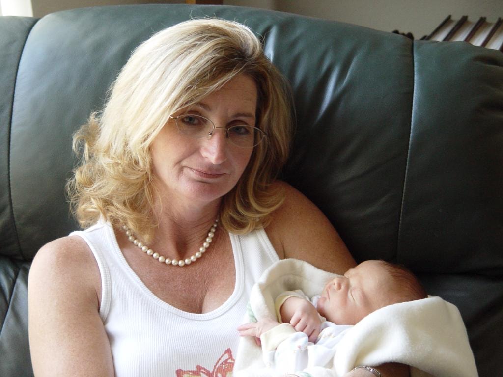 Woman holding newborn baby on couch