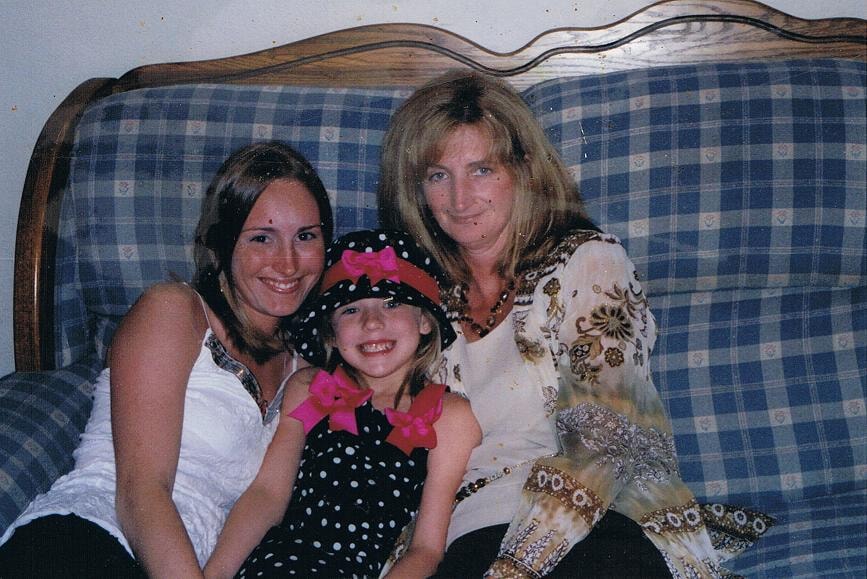 Three people on couch with child in hat