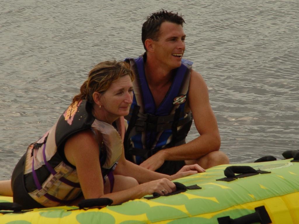 Two people on inflatable tube on water