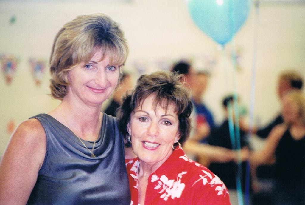 Two women smiling at party with balloons