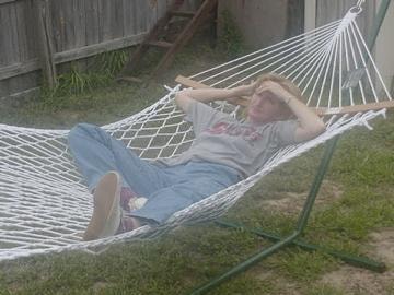 Person relaxing in hammock backyard