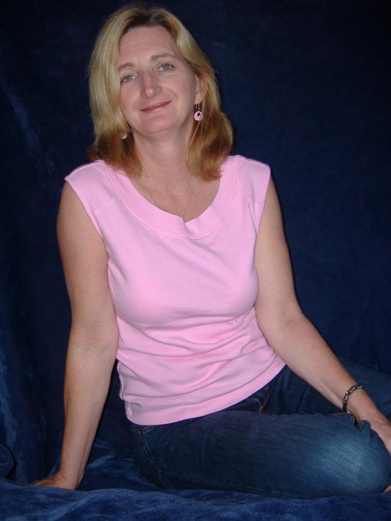 Woman in pink top blue backdrop portrait