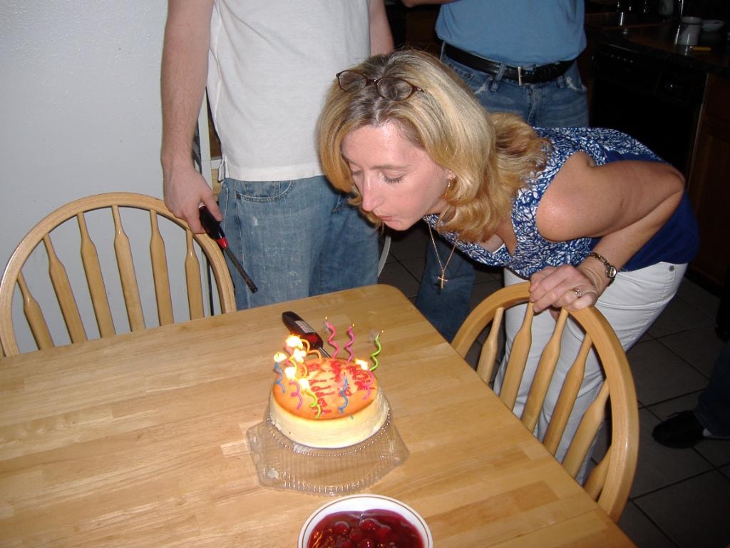 Woman blowing out birthday cake candles