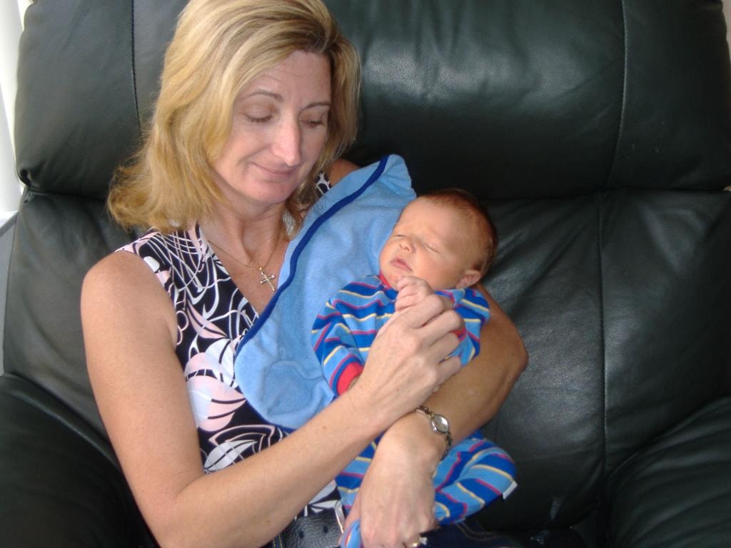Woman holding newborn baby in recliner