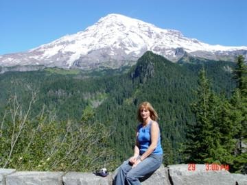 Woman sitting on rocks with snow-capped mountain backdrop