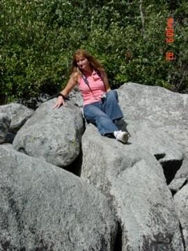 Woman sitting on large rocks outdoors