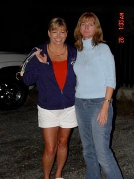 Two women posing together outdoors at night