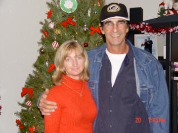 Couple posing in front of Christmas tree