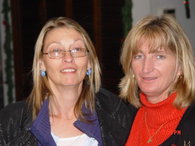 Two women smiling together at holiday gathering