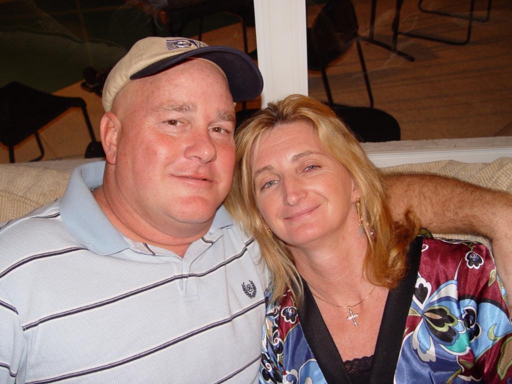 Couple smiling together indoors man in baseball cap