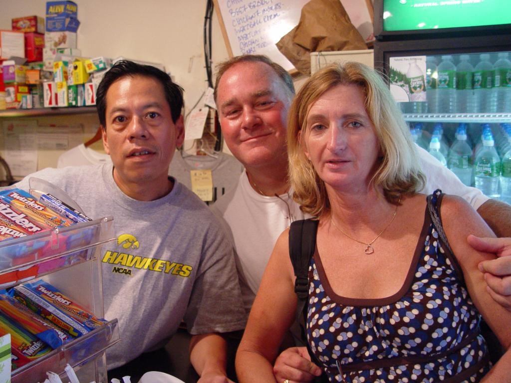 Three people at deli counter Hawkeyes shirt