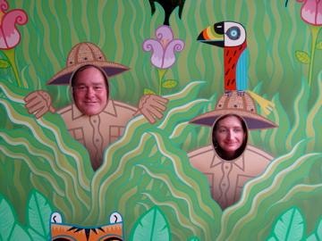 Couple posing in jungle cutout photo board