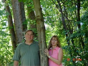 Couple standing among trees in wooded area