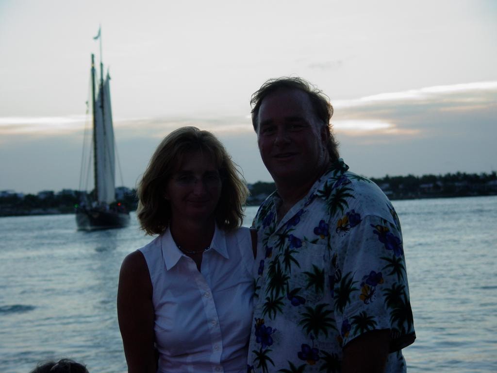 Couple at waterfront with sailboat at sunset Key West