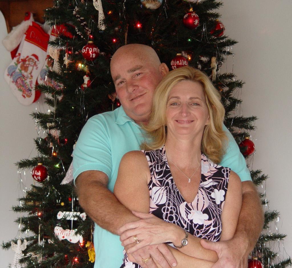 Couple embracing in front of decorated Christmas tree