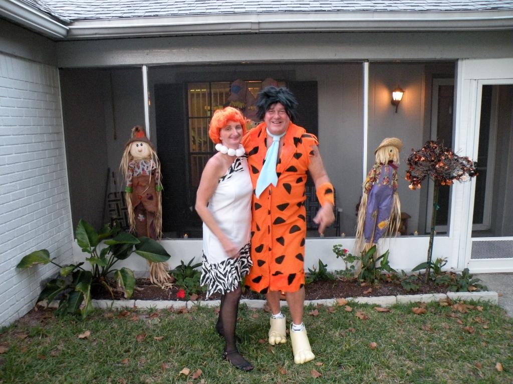 Couple in Flintstones costumes Fred and Wilma outdoors