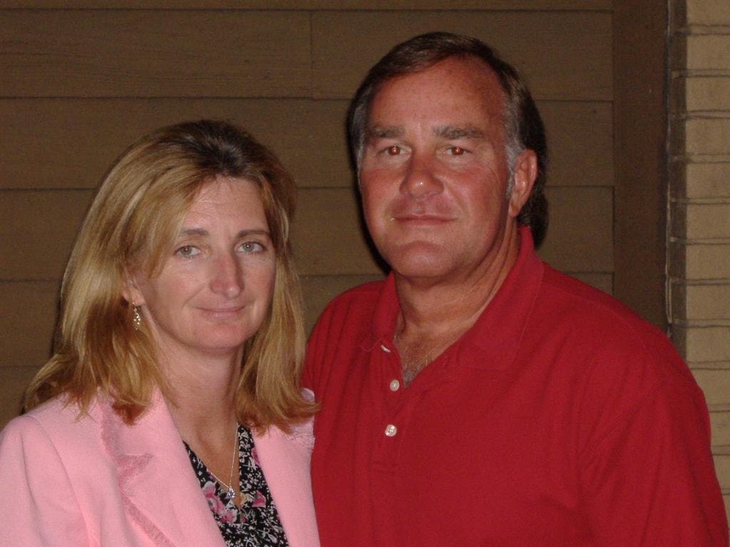 Couple posing together outdoors woman in pink blazer