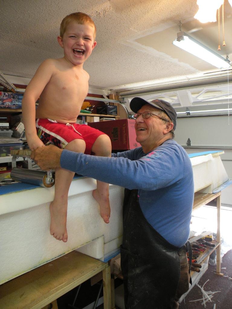 David Zettel laughing with a grandchild in the workshop